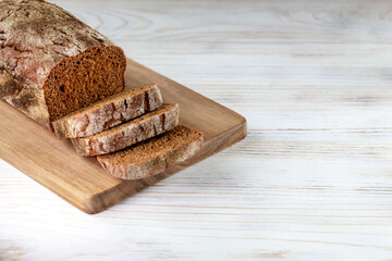 Bread with slices on a wooden background