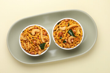 Indian Namkeen Snacks or Navratna Mix Namkeen served in ceramic bowl and plate. Also Know as Namkin, Mixture, chiwda