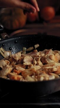 Vertical video of seasoning a pan of simmering chicken adobo, traditional Filipino dish