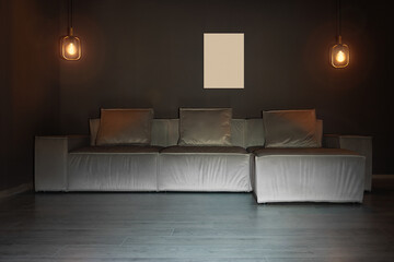 Gray corner sofa with lamps and blank picture, loft style