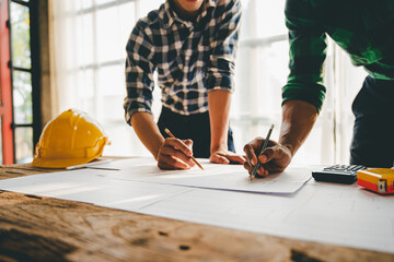 Engineers work as a team with blueprints for architectural plans. Engineer sketching construction project concept with architect equipment Architects talking at table Teamwork and construction concept