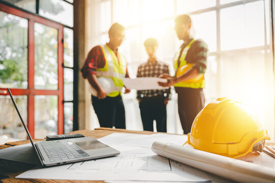 Engineers work as a team with blueprints for architectural plans. Engineer sketching construction project concept with architect equipment Architects talking at table Teamwork and construction concept