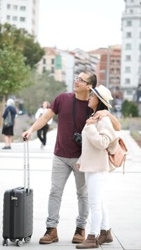 Happy multiracial couple of tourists exploring the city together and pointing. Sightseeing in Madrid, Spain.