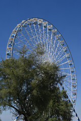 ferris wheel at a funfair on a background of blue sky