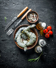 Whole raw shrimps in bowl with tomatoes and spices.