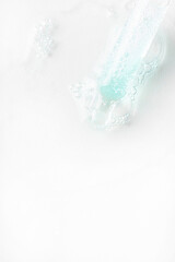 Abstract Pipette dropper with lught blue liquid drops on white background. Concept for Laboratory investigation, medicine, science research, cosmetic and perfume industry