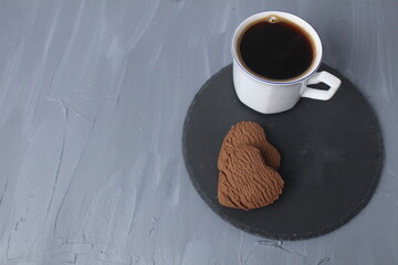 breakfast on Valentine's Day coffee and biscuits heart on a tray black on a gray background with a place for text copyspace. Food romantic surprise