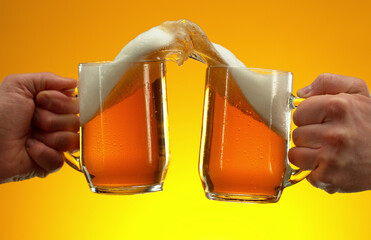 Two glasses of beer in cheers gesture, splashing.