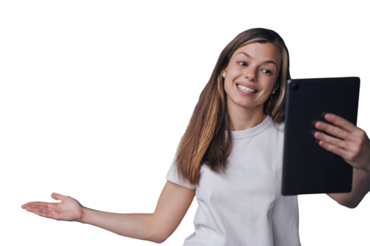 Excited Spanish brunette young woman holds tablet makes video call broad smiles against transparent background. Cheerful Italian girl enjoys leisure, points view on background behind her via internet - Powered by Adobe