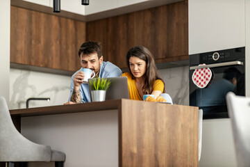 Couple in modern kitchen smiling at each other