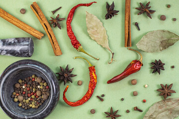 Pattern of their fragrant spices and seasonings on green, top view of seasonings and spices