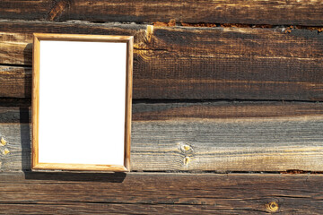 Empty frame with white field on the background of an old wooden wall, frame mockup with ad or image, space for text, copy space