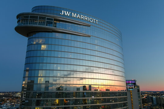 aerial shot of the JW Marriott Hotel and office buildings in the city skyline at sunset with cars driving on the street on the riverfront and a gorgeous blue sky with clouds in Nashville Tennessee USA