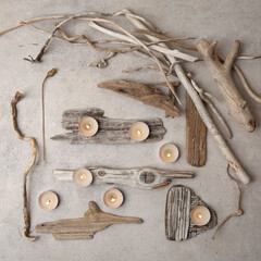 Sea driftwood pieces and tea light candles on stone background. Pieces of sea drift wood, top view. Bleached dry aged drift wood.