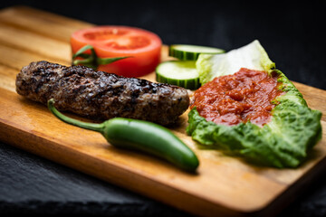 Kebapche is a meaty treat that will make your taste buds dance like a traditional Bulgarian folk dance. It's a sausage-shaped patty made of ground meat. Surrounded by green pepper, lutenica and tomato