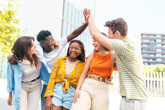 Group of happy multiracial friends having fun outdoors - Cheerful young people laughing together at city - Friendship concept.