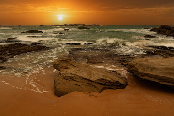 Fototapeta na wymiar beautiful sunset over the indian ocean with rocks in the foreground sri lanka