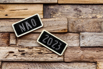 ardoise étiquette sur fond en bois : NAO 2023
