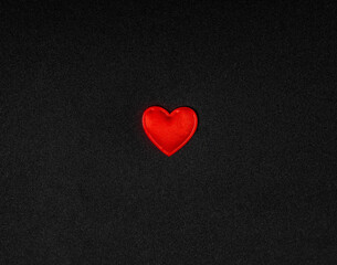 Red heart on a black background of fabric