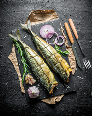 Delicious smoked mackerel fish with rings of fresh onions and garlic cloves.