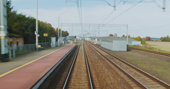 View from the rear window of the train on the platform and railway tracks city train road trip window from the side of the last carriage POV panorama Poland.