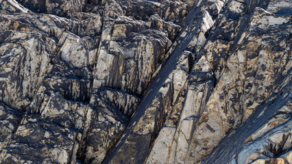 A variety of geological strata as a background. Stone texture, full frame.