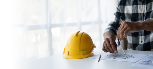 Engineer drawing a blue print design building or house, An engineer workplace with blueprints,...