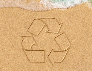 Logo of recycling drawing on sand on seashore. Concept of water pollution and protection