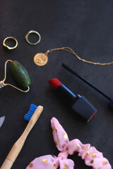 Various beauty products, accessories and jewelry on dark background. Selective focus.