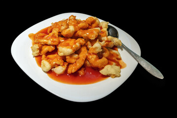 Fried chicken pieces with sauce on a white plate