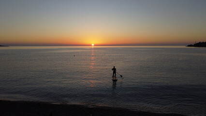 Man on a sup board at sunset