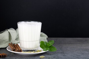 Popular Indian cold drink - Lassi. Yoghurt drink with spices and mint on a black background. The...