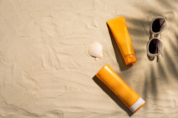 Sunblock lotion bottles on sandy beach