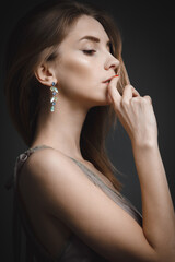 Portrait of a young attractive girl in an evening dress on a dark background.