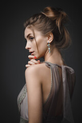 Portrait of a young attractive girl in an evening dress on a dark background.