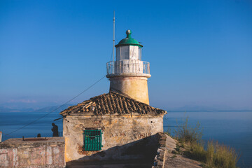 Fototapeta na wymiar View of Old Venetian Fortress of Corfu, Palaio Frourio, Kerkyra old town, Greece, Ionian sea islands, with the lighthouse, Clock tower, st. George church and the city, a blue sky summer sunny day
