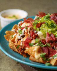 Rich nachos with meat and Italian sausage, 5 cheese sauce, guacamole, Mexican-style sour cream