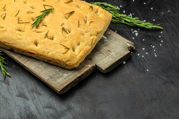 foccacia bread. olive oil and herbs on a dark background. banner, menu, recipe place for text, top view