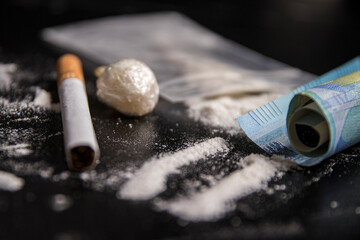 Drug Abuse: Close-up of a cigarette and a 20 euro banknote on a table full of cocaine