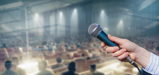 Holds out a microphone speaker .