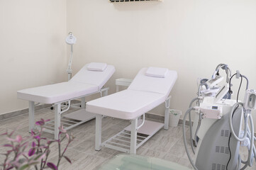 White and comfortable SPA bed standing in the middle of professional, clean and hygienic room for facial and body treatments.Modern ways of relaxation and skin care