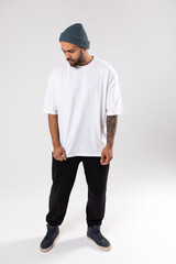 Stylish african american man in a white t-shirt stands a white background. Mock-up.