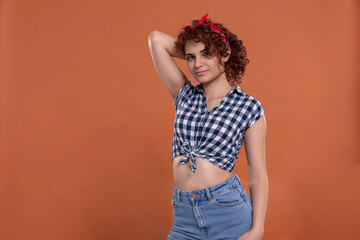 Pin up styling. Girl in short plaid shirt. Curly hair.