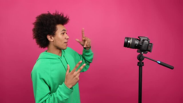Portrait of a popular blogger using his camera to record a vlog. Close-up view of young African American guy connecting with his followers. High quality 4k footage