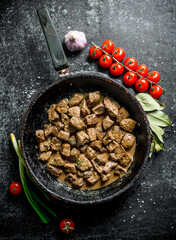 Fried pieces of liver with garlic, cherry tomatoes and Bay leaf.