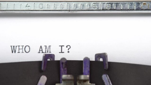 Who Am I phrase close up being typing and centered on a sheet of paper on old vintage typewriter mechanical