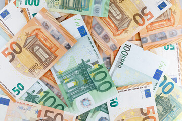 A pile of banknotes on the table of different denominations. Background of mixed euro banknotes. Close-up