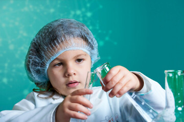 Little kid doing experiments with blue liquid. Cute child wants to become a doctor. Pretty child in...