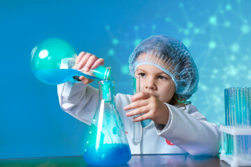 Little kid doing experiments with blue liquid. Cute child wants to become a doctor. Pretty child in white medical robe holds glass flasks with blue liquid on indigo background with hospital symbol.