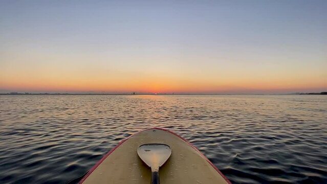 SUP Paddleboard nose on water at sunrise